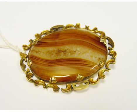 Victorian gold coloured metal and banded agate brooch, with oval polished stone within open scroll surround 6cm wide