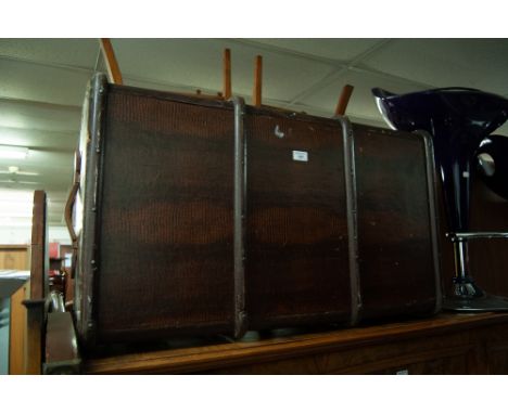 A LEATHER BOUND TRAVELLING TRUNK, WITH END HANDLES 