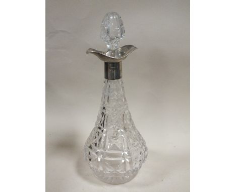 A LARGE CUT GLASS DECANTER WITH HALLMARKED SILVER COLLAR 