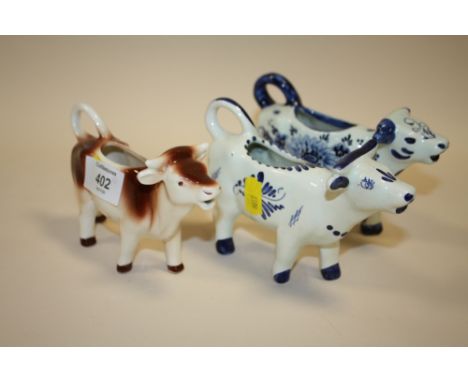 THREE CERAMIC COW CREAM JUGS TO INCLUDE A  GOEBEL EXAMPLE