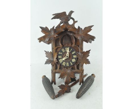 A Swiss or Black Forest style cuckoo clock with pendulum and weights, case 29cm high