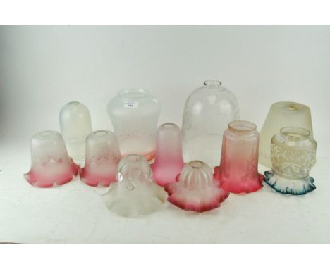 A collection of glass lamp shades, including shaded cranberry, vaseline and others, largest 21cm high