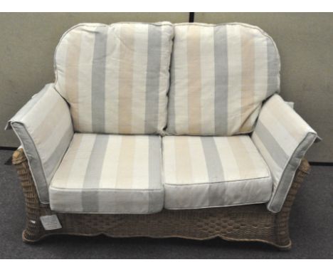 A modern wicker two seat sofa, with six cushions, 91cm x 135cm x 95cm