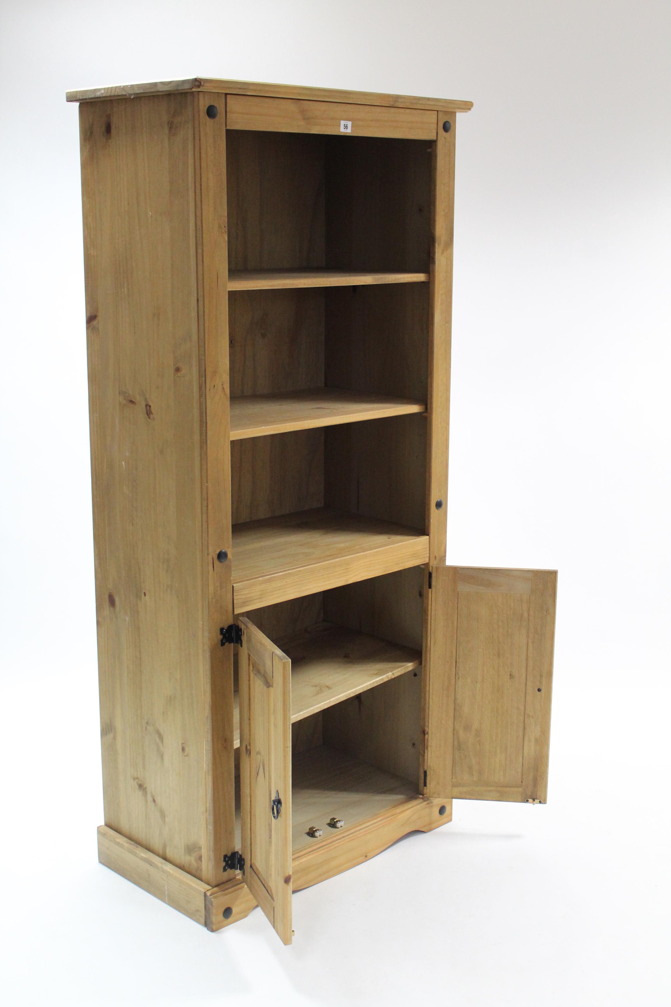 A pine tall standing bookcase with two open adjustable shelves above