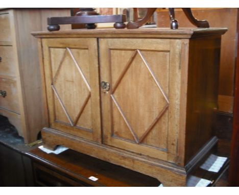 An antique oak chest, the rectangular top over two short and three long geometrically panelled drawers, each with brass teard