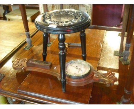A late Victorian oak framed wheel barometer, together with an ebonised stool with chip carved floral decoration on three turn