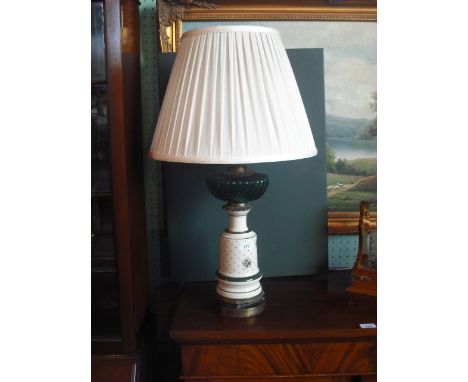 An Irish ceramic table lamp (converted), having a green glass wrythen reservoir over mallet shape body, transfer decorated wi