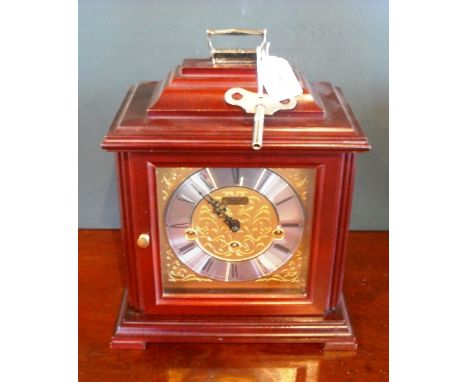 A contemporary mantle clock by Rapport, the Georgian-style mahogany veneered case enclosing a German Westminster chiming move