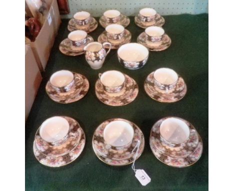 An Edwardian Staffordshire bone china tea service, comprising twelve cups, saucers and plates, cream and sugar, each hand dec