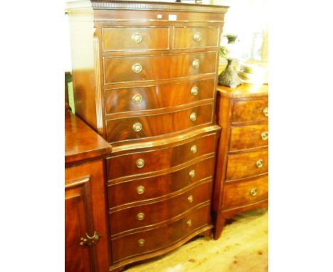 A reproduction mahogany chest on chest of serpentine fronted form, having moulded and dentil cornice over two short and three