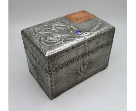 An Arts and Crafts metal covered playing card box, containing two packs of playing cards 