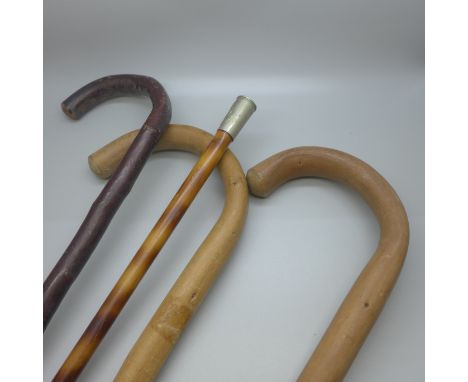 A military swagger stick, The Green Jackets emblem, and three other wooden walking sticks