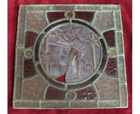 A square leaded-light coloured glass frame, the circular central panel depicting a stonemason at work, 30.5cm square, (a/f) a