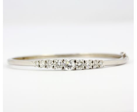 A 925 silver bangle set with graduated round cut cubic zirconias, dia. 6.5cm.