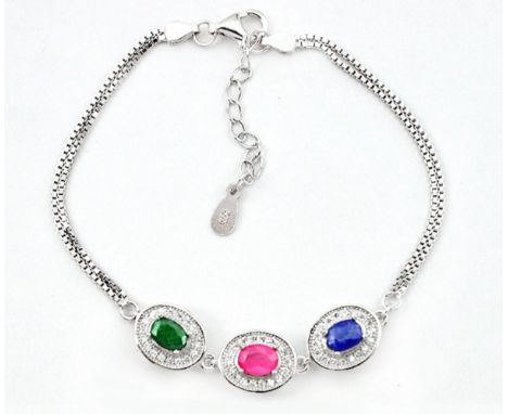 A 925 silver bracelet set with an oval cut sapphire, ruby and emerald, surrounded by white stones, L. 19cm.