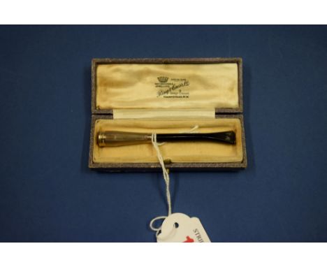 An 9ct gold engine turned cigarette holder, cased.