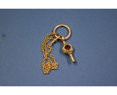 An unmarked fancy watch key set ruby and agate, having an unmarked yellow metal bale and chain attached, 8g total.   Conditio