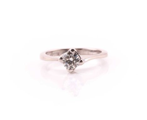 A single stone diamond ring; the round brilliant cut diamond in square four claw setting, to a plain white metal shank marked