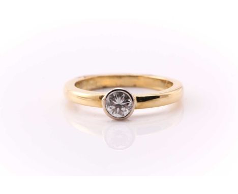 A single stone diamond ring; the round brilliant cut diamond in collet mount to a plain,18 carat, polished, D section shank. 