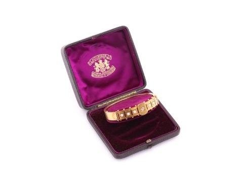 An Edwardian diamond and pearl bangle, consisting of an old mine cut diamond approximately sized 3.6 x 3.3 mm, star set in th