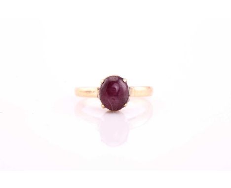 A star ruby ring, the oval 7.7 by 6.5 by 5.3mm cabochon in pinkish-purple, claw set to a yellow precious metal mount and simp
