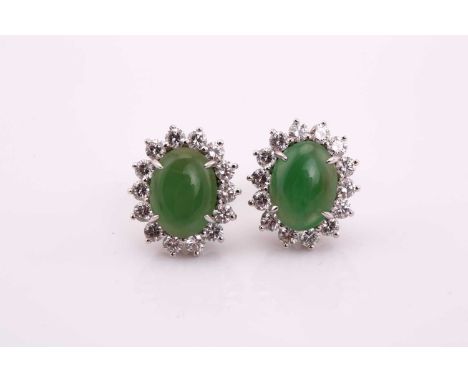 A pair of jadeite entourage ear studs, each consisting of an oval jadeite jade cabochon, approximately sized 8.9 x 6.7 mm, cl