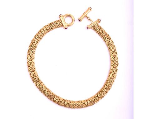 An 18ct gold and ruby Byzantine chain necklace, consisting of flat Byzantine links approximately measuring 13 mm wide, with a