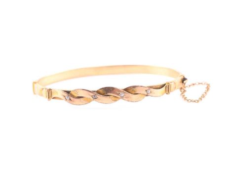 A hinged diamond bangle, consisting of four old mine cut diamonds of estimated carat weight 0.04, star set on a gold bangle w