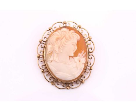 Shell cameo brooch, oval female profile portrait cameo, to yellow precious metal mount with ornate scroll surround, unhallmar