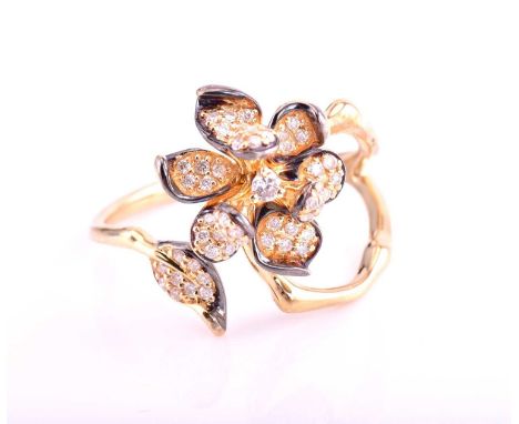 A diamond set flower ring; 18 carat gold, pavé set to one terminal with a six petal flower around a central diamond; bifurcat