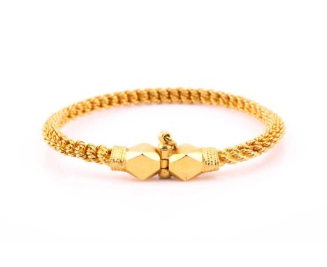 A yellow metal torque style bangle, the rope twist bangle with faceted terminals and screw-down fastening, interior 6cm by 5.