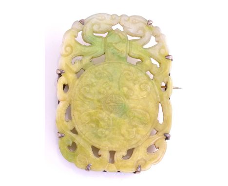A carved jade panel brooch of rectangular pierced form, overall 65mm by 20mm, 50grams gross.