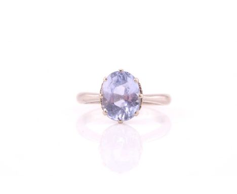 A single stone pale sapphire ring; the oval cut stone 9.94mm x 7.72mm; in 18 carat white gold eight claw mount, to an engrave