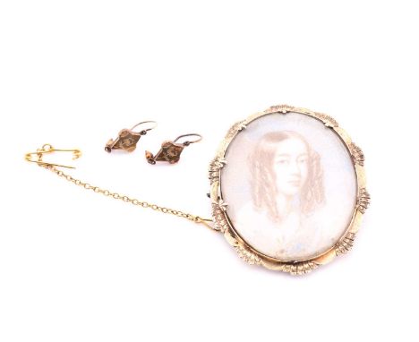 An early 19th century portrait miniature in a yellow precious metal brooch mount, depicting a young woman with ringletted hai