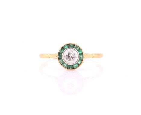 An Art Deco diamond and emerald target ring, consisting of a central round old European cut diamond, estimated weight of 0.67