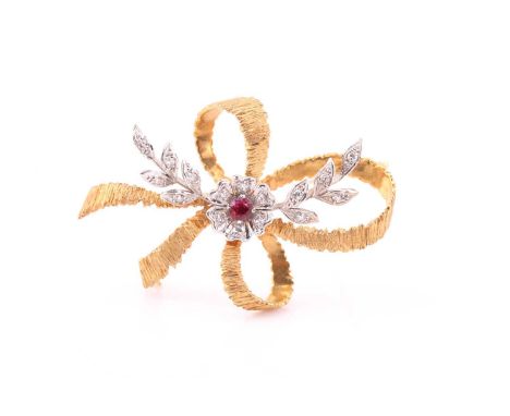 A ruby and diamond ribbon brooch, consisting of a ruby accent approximately sized 3.2 mm, with 16 round brilliant diamonds be