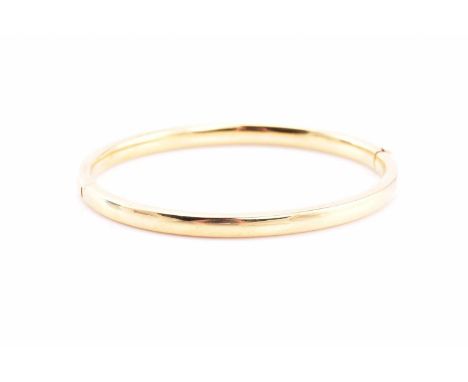 Cancer Research UK Charity lotAn 18ct yellow gold hinged bangle, of oval form, the interior measures 5.8cm by 5.2cm.12.9grams
