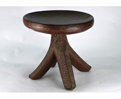 An old carved hardwood tripod stool of African origin, 32 cm dia. x 30 cm h