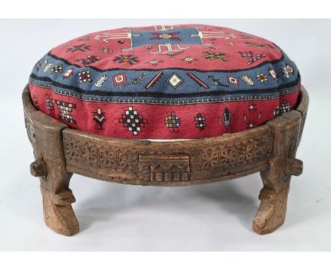 An antique Indian carved table, 76 cm dia. x 27 cm h to/with a carpet cushion