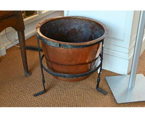 An antique copper tub within an iron tripod cradle, 54 cm dia. x 50 cm h