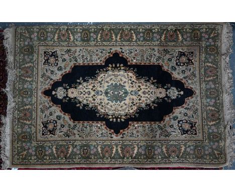 An Indo-Persian rug, jade-green ground centred by a dark blue medallion panel, 210 cm x 138 cm&nbsp;