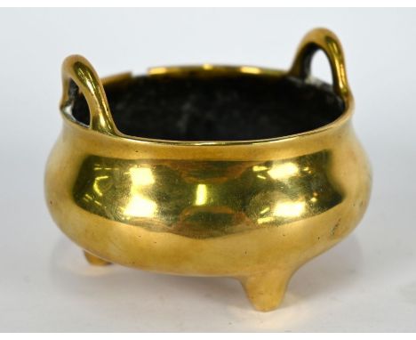 A small 19th century Chinese brass tripod censer of compressed globular form with loop handles, the base with six-character X