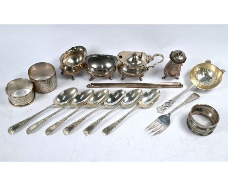 An Edwardian set of six bright-cut silver teaspoons, Sheffield 1904, to/w a tea strainer with pierced finial, three napkin ri