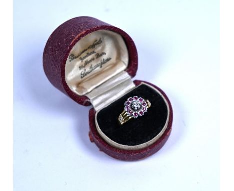 An antique 18ct yellow gold ring set with white gold ruby and diamond flower cluster, with open diamond set shoulders, stampe