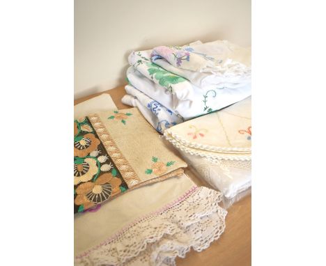 Eight peices of mid-century vintage home textiles, including six hand embroidered tablecloths or furniture coverings in vario