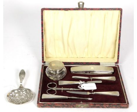 An Art Deco silver mounted engine turned manicure set in fitted case and a pierced silver spoon (2) 