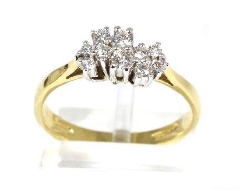 An 18 carat gold diamond ring, an undulating cluster of vari-sized round brilliant cut diamonds in claw settings, to knife ed