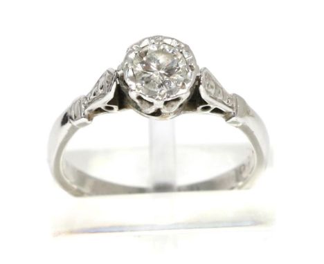 A solitaire diamond ring, a round brilliant cut diamond in an illusion setting, to diamond-cut angular shoulders, estimated d