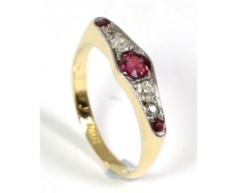 An early twentieth century ruby and diamond ring, a round cut ruby spaced by four graduated old cut diamonds and two further 