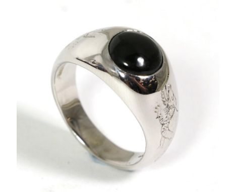 An 18 carat white gold onyx signet ring, a round cabochon onyx inset to a tapering shank with engraved Chinese dragons, finge